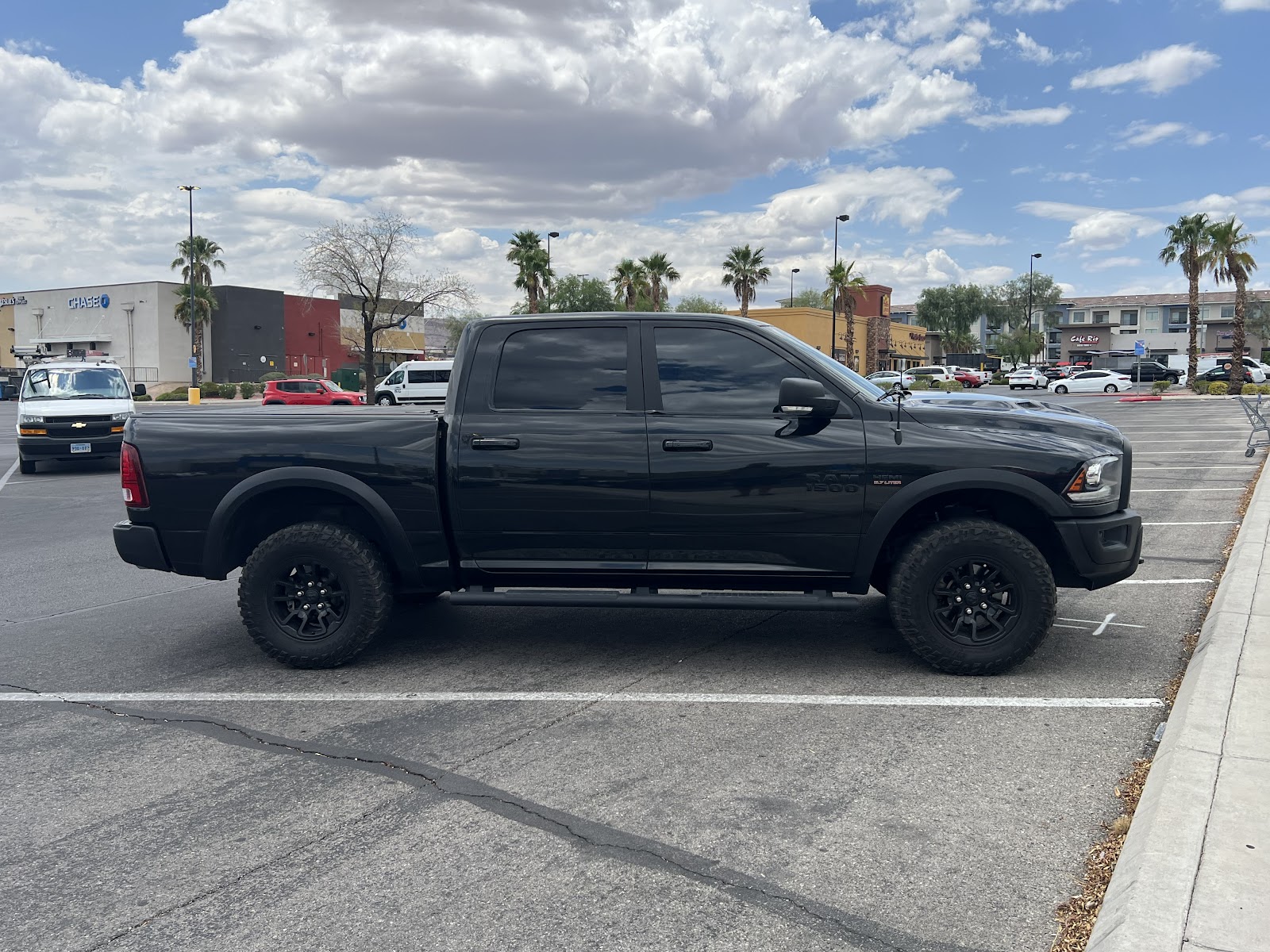 Black Ram 1500 Rebel truck with tinted windows in a parking lot