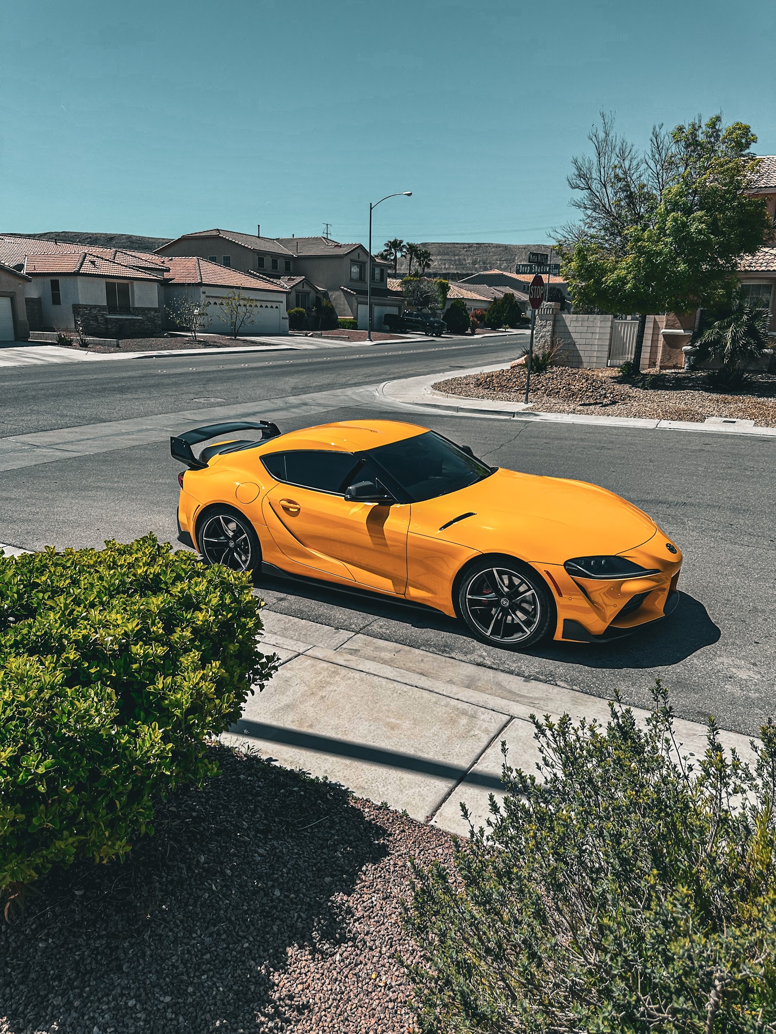 Yellow Toyota Supra with tinted windows parked on a suburban street